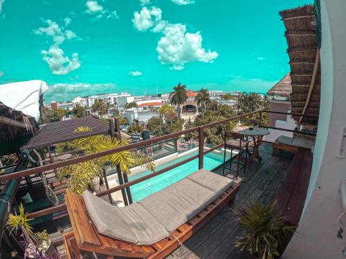 普拉亚卡门Maui Hostels Playa del Carmen的阳台设有游泳池和桌椅。