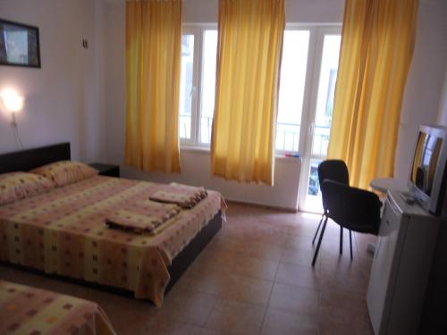阿赫托波尔"Agatopolis" - подсигурено безплатно паркиране的酒店客房设有两张床和电视。