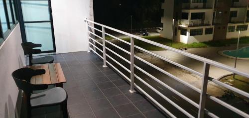 Kota SamarahanRegalia Apartment B-3-1 Kota Samarahan的阳台配有桌椅和栏杆。