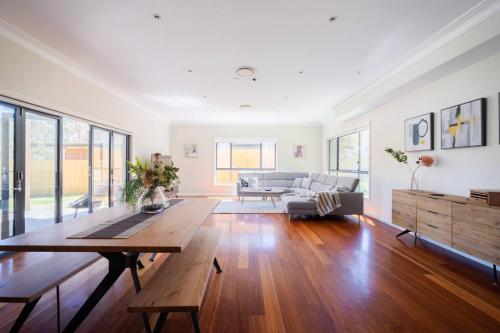 卢拉Alleura House Serene Bushland 4BR Families Groups的客厅配有沙发和桌子