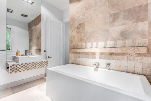 卢拉Villa Northcote Luxurious 4BR Wood Fireplace Leura的一间带大浴缸和水槽的浴室