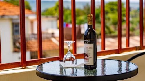 基苏木Whirlspring Hotel的一张桌子上坐着一瓶葡萄酒和一杯葡萄酒