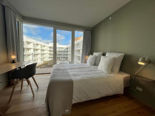 哥本哈根STAY Nordhavn的一间卧室配有一张大床、一张书桌和一个窗户。