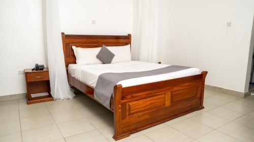基苏木Whirlspring Hotel的一间卧室配有一张带白色床单的木床