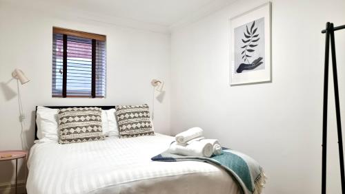 卡迪夫Thompson Apartments by Switchback Stays的白色卧室,配有带毛巾的床