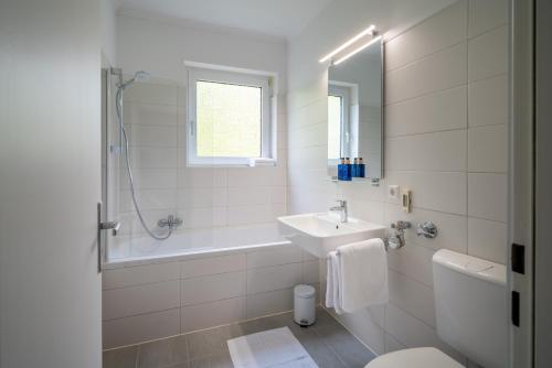 巴登-巴登Blue Sky Apart Center Baden-Baden的白色的浴室设有水槽和浴缸。