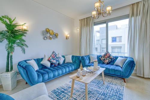 开罗Residential Suites near AUC by ELEGANT的客厅配有蓝色的沙发和桌子