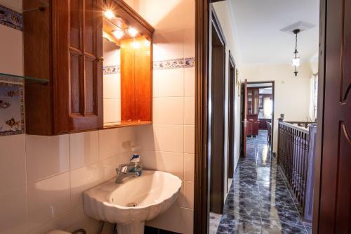 卡尔帕索斯Oceanviewvilla的一间带水槽和镜子的浴室以及走廊