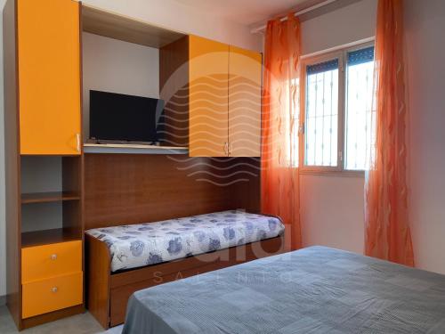 托雷拉皮罗Villa Teresa - giardino privato的一间卧室配有一张床,墙上配有电视
