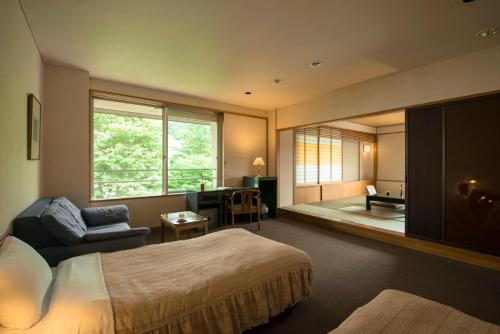 藏王温泉高宫光亮酒店的卧室配有床、椅子和窗户。