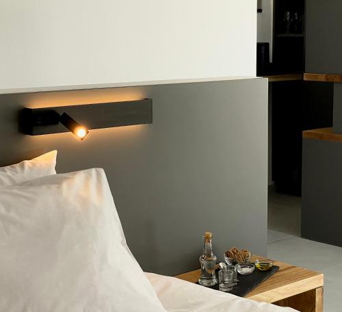 SívasO Mikros Kosmos Hotel Resort - Adults Only的一间卧室配有一张床和一张桌子,上面有饮料