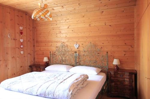 泰塞罗CASA PAMPEAGO - Sulle piste da sci del Latemar的一间卧室配有一张木墙床