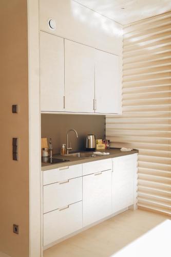 迪德朗日Floater的厨房配有白色橱柜和水槽