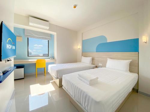 曼谷Hop Inn Bangkok Bangna的酒店客房配有两张床和一张书桌