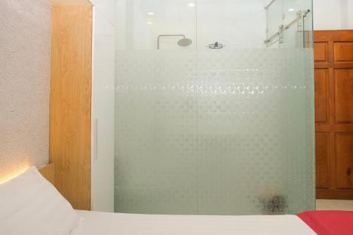 边和Lộc Thiên Ân hotel的卧室内的玻璃淋浴间,配有床
