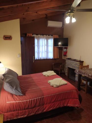 查斯科穆斯Cabañas El Refugio的一间卧室配有一张带红色毯子的大床
