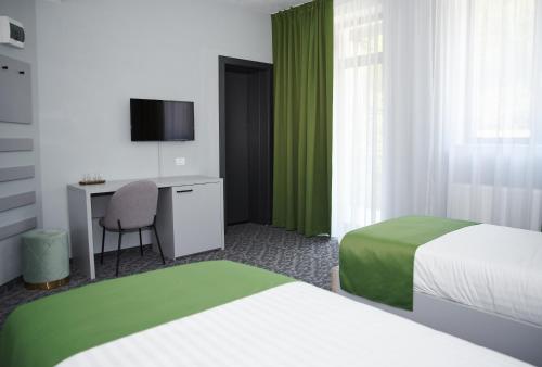 克利默内什蒂Astra Hotel的酒店客房配有两张床和一张书桌