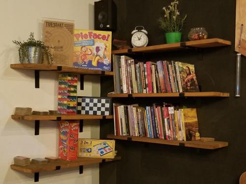 当格浪CoffeeBunk Hostel的墙上挂着木架,上面装满了书籍