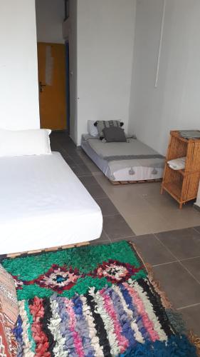 塔哈佐特Puppyblue的一间设有两张床的客房,地板上铺有地毯。