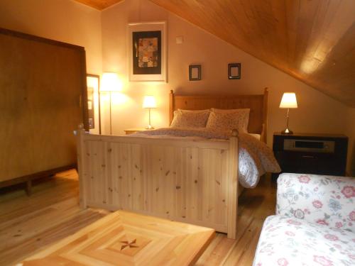 辛特拉辛特拉小型旅馆的一间卧室配有一张木床、两盏灯和一张沙发。