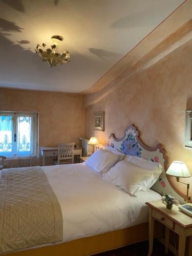 蒙托波利因瓦尔达尔诺Quattro Gigli Palace的卧室配有一张带两张桌子的大型白色床
