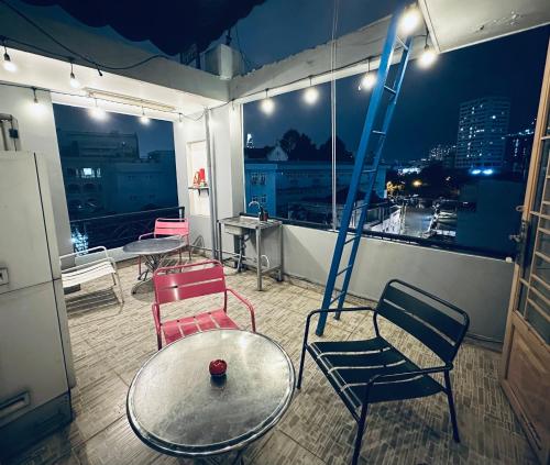 胡志明市Alleyway Hostel的一间带椅子和桌子的房间以及梯子