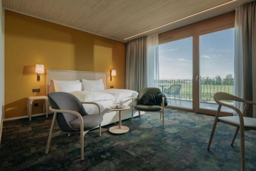 FeldkirchLandhotel Bohrerhof的酒店客房带床、椅子和窗户