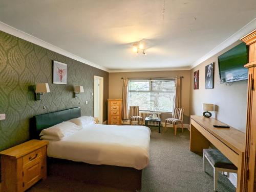 伯恩茅斯名流酒店（原品质伯恩茅斯酒店）的配有一张床和一张书桌的酒店客房
