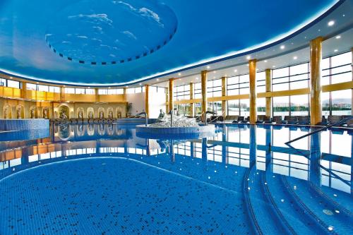 阿然德洛维克A Hoteli - Hotel Izvor的一座大楼中央带喷泉的大型游泳池