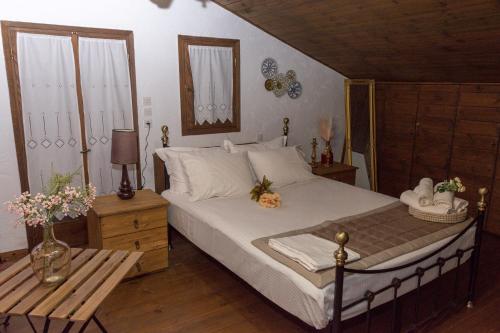 PalamásArxontiko Palamas的一间卧室配有一张床和一张鲜花桌