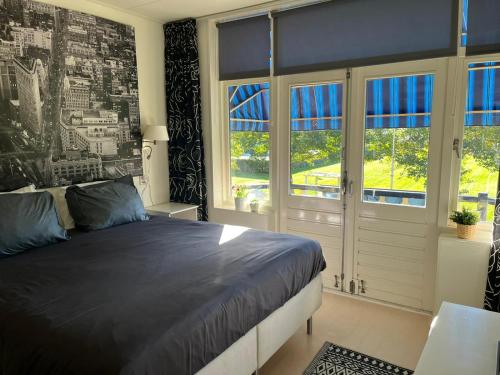 海边的艾格蒙特B&B de Zandtaart的一间卧室设有一张大床和窗户。