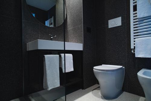 古比奥Hub Hotel的一间带卫生间、水槽和镜子的浴室