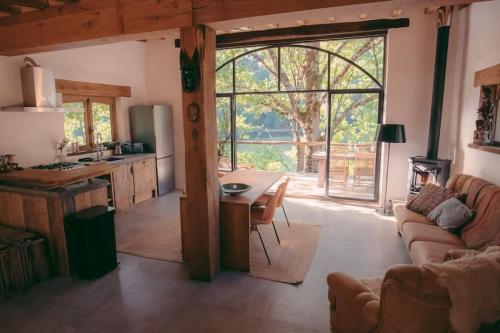 Castelnau-de-MandaillesLake House I // Alauzet Ecolodge + Nature spa的厨房以及带桌子和沙发的客厅。