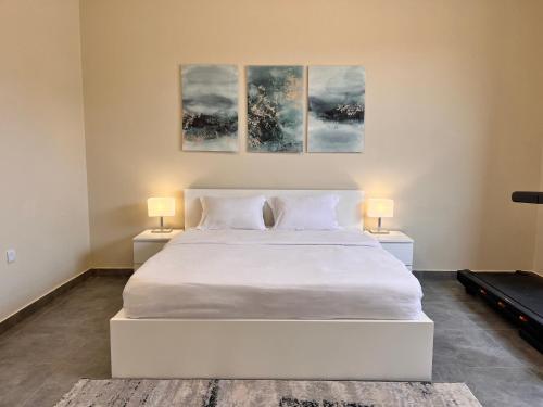 拉斯阿尔卡麦Pool Villa Saraya的一间卧室配有一张带两盏灯的大型白色床。