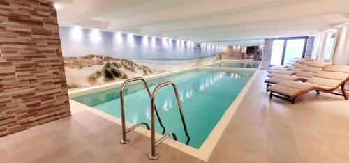 韦斯特兰叙尔特岛布劳姆谢酒店的一个带椅子的游泳池和一个带壁画的墙壁