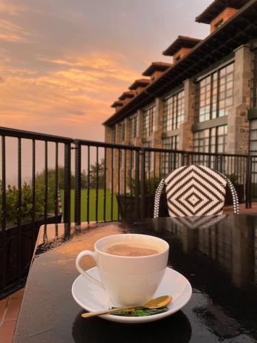 坎加斯-德奥尼斯Hotel Mirador de la Cepada的坐在阳台上的桌子上喝杯咖啡