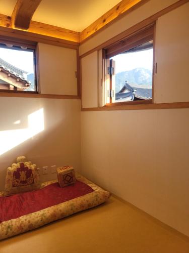 首尔Chaehyodang Hanok Stay的客房设有一张床和两个窗户。