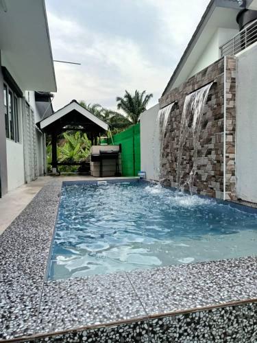 大港Homestay Sungai Besar with Private Pool RUMAH HANA的房屋前的游泳池