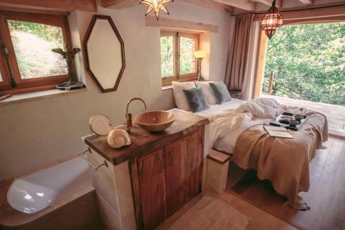 Castelnau-de-MandaillesPrivate Estate with 3 Lake Houses, Sauna & Hot-tub的一间卧室配有一张床和一个水槽和一个浴缸