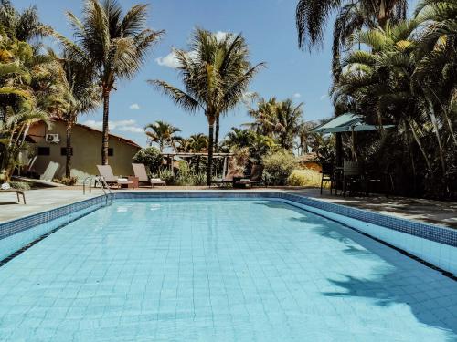 戈亚斯州上帕莱索波萨达瑞坎托格兰达巴斯酒店的一座棕榈树环绕的游泳池