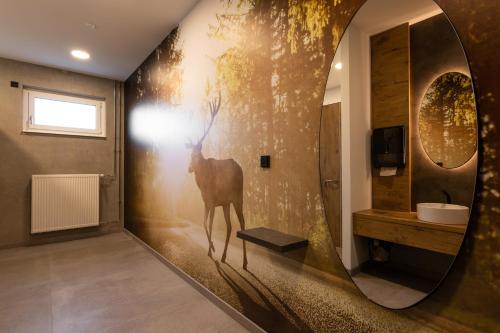 LichtenauHotel am Sonnenlandpark的浴室墙上挂着鹿的画作