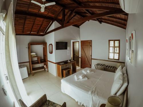 戈亚斯州上帕莱索波萨达瑞坎托格兰达巴斯酒店的卧室配有白色的床和电视。