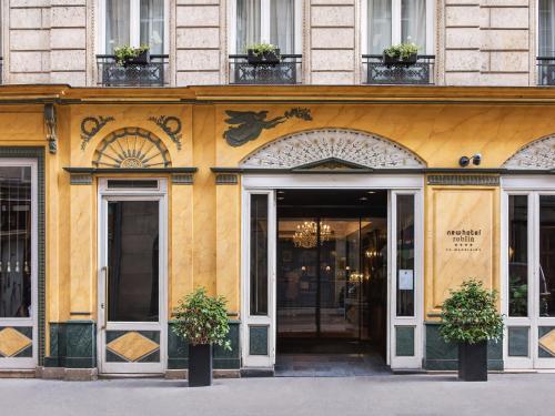 巴黎New Hotel Roblin的前面有门和植物的黄色建筑