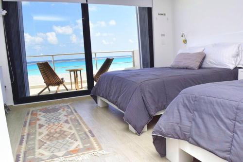 坎昆Ocean front Villa Marlin, best location in hotel zone #109的一间带两张床的卧室,享有海景