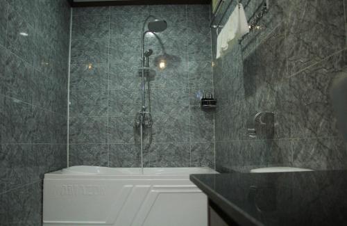 万荣Confetti Garden Resort的带淋浴、浴缸和盥洗盆的浴室