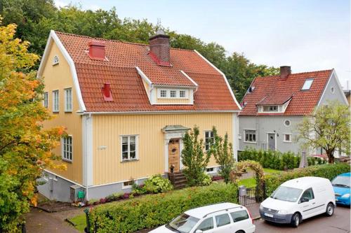 哥德堡5:ans住宿加早餐酒店的一座黄色的房子,两辆车停在停车场