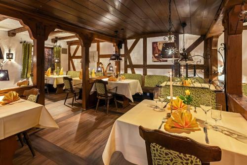 施马伦贝格亚伯斯兰德酒店的餐厅设有白色的桌椅和木制天花板。