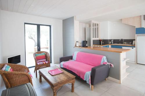 滨海拉库阿尔德Les Maisons de l'Olivette的一间带粉色沙发的客厅和一间厨房