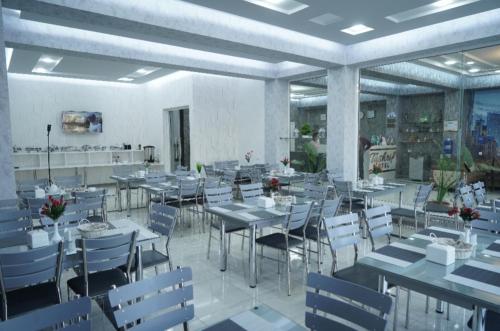 卡尔希TASHRIF HOTEL的用餐室配有桌子和白色椅子