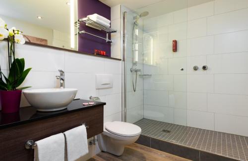 美因河畔法兰克福法兰克福市中心莱昂纳多酒店的一间带水槽、卫生间和淋浴的浴室